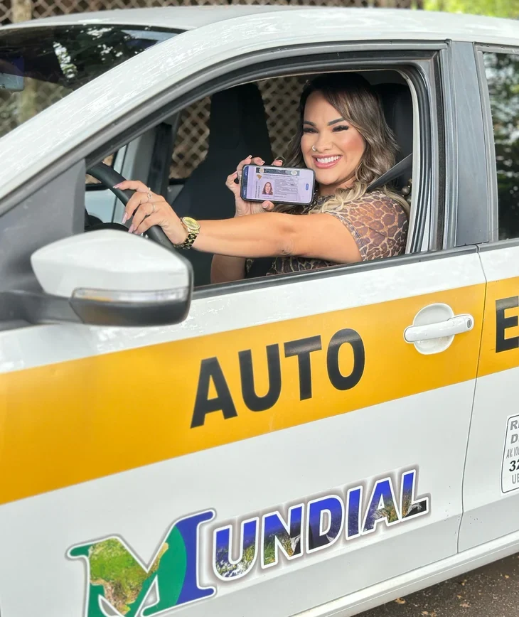 Aluna da Mundial sorrindo dentro do carro da autoescola
